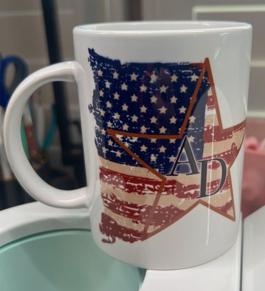 White ceramic mug printed with the American Dreamer distressed-flag star logo